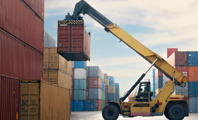 A yellow crane picking up a cargo container | SAP Linfox