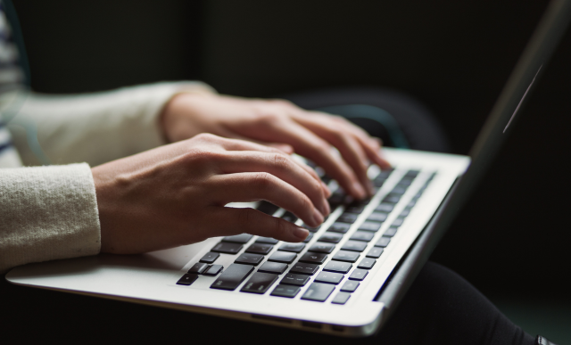 A zoomed in angle of a person typing on a laptop | Basis Technologies