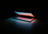 photograph of a switched on laptop in a dark room