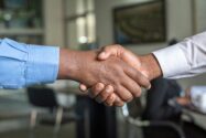 a photograph of two people shaking hands, agreement and contract concept