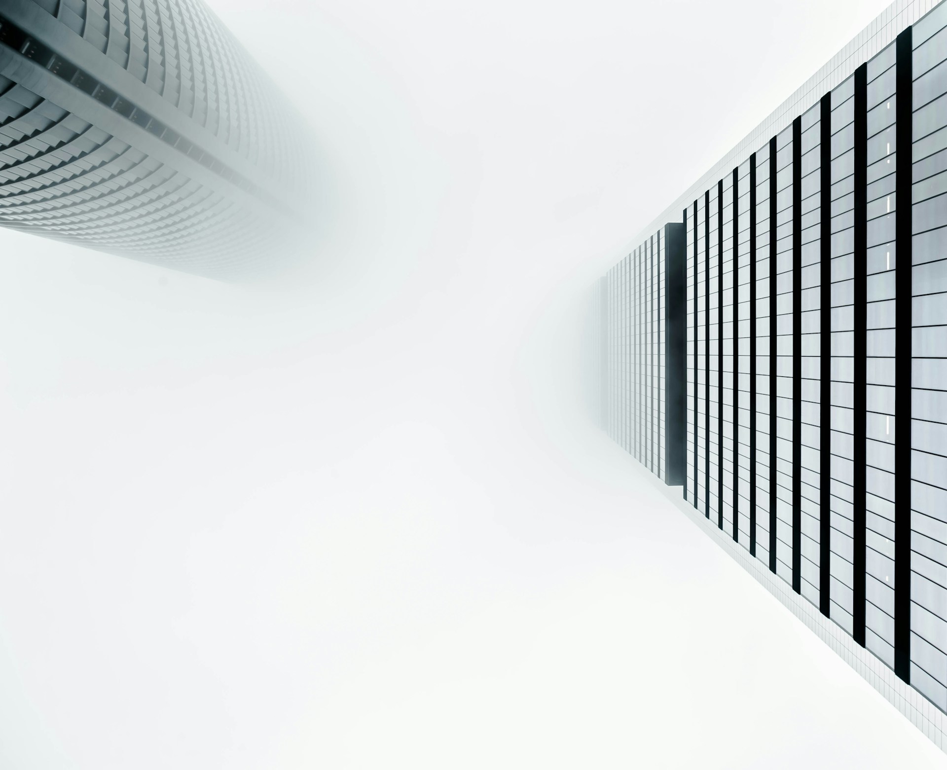 a photograph of two skyscrapers disappearing in the cloudy sky - cloud concept