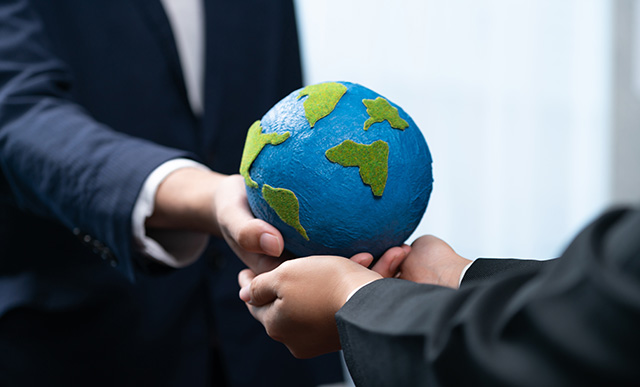 image of two people in business suits holding the world in their hands