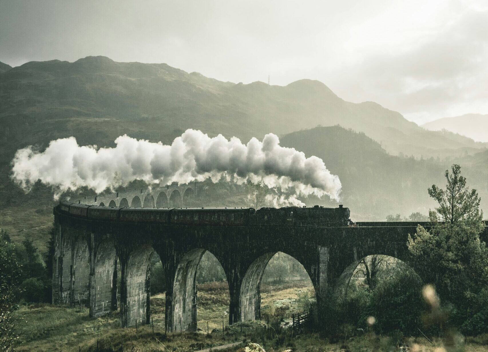 old train on a bridge in a mountain and countryside area | manufacturing cycle train with SAP