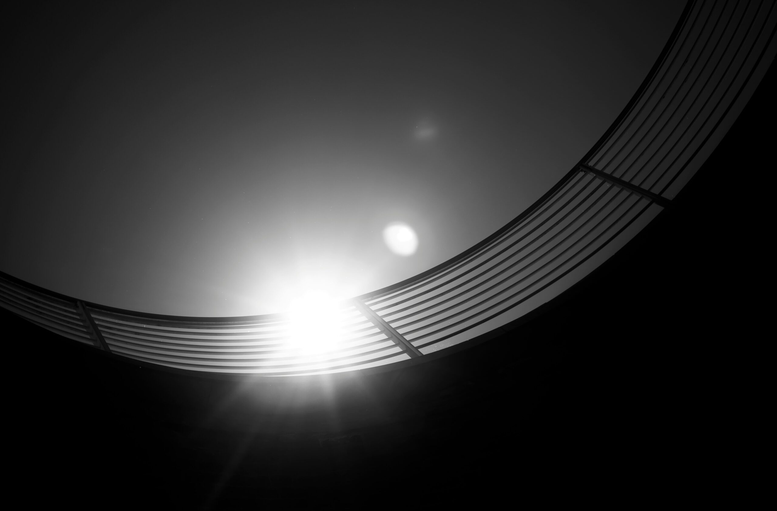 black and white photo of a circular building and railings with the sun shining through them | SIOS Technology solution for HA in SAP systems