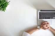 a top-down shot of a person wearing a watch sitting near laptop | STA Technologies automation solution for HR functions