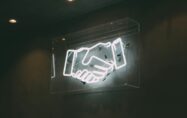 a neon sign of a handshake | SAP and UiPath partnership