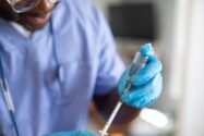 a medical professional in scrubs using a syringe