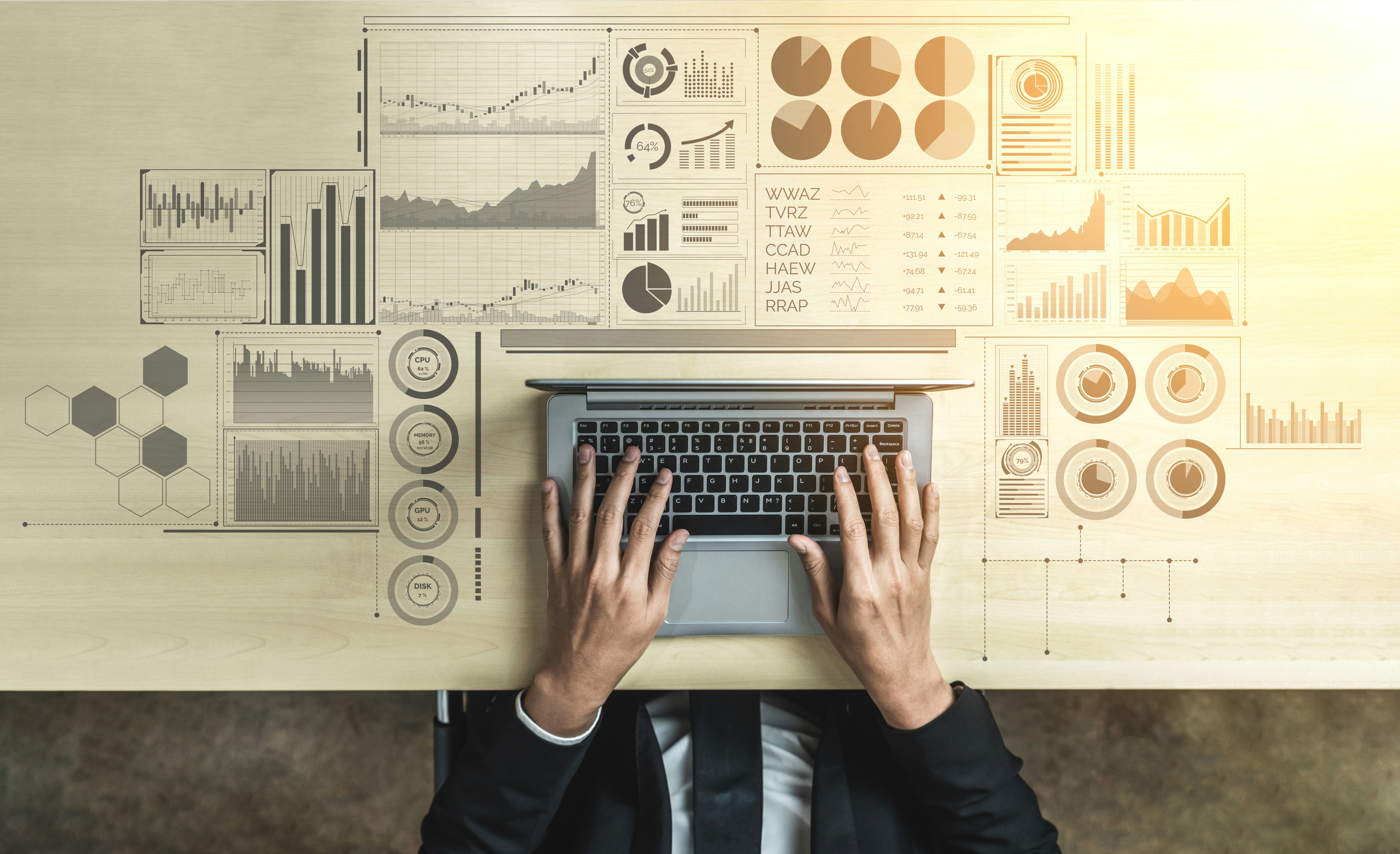 a person typing on a laptop with finance graphics in the background | All eyes on spend management as the CFO’s office is up for rehaul