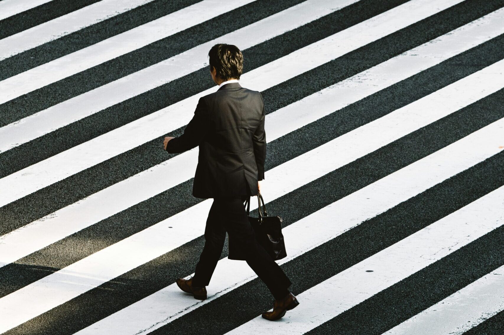 a businessman crossing a black&white striped road | Lemongrass Cloud solution for SAP S/4HANA migration