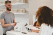 a woman using her phone to pay at a shop till | Accelerating the B2B commerce journey with Capgemini’s Fast Commerce for SAP Customer Experience