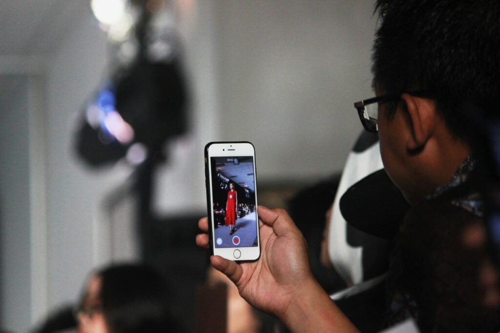 A man recording fashion show.