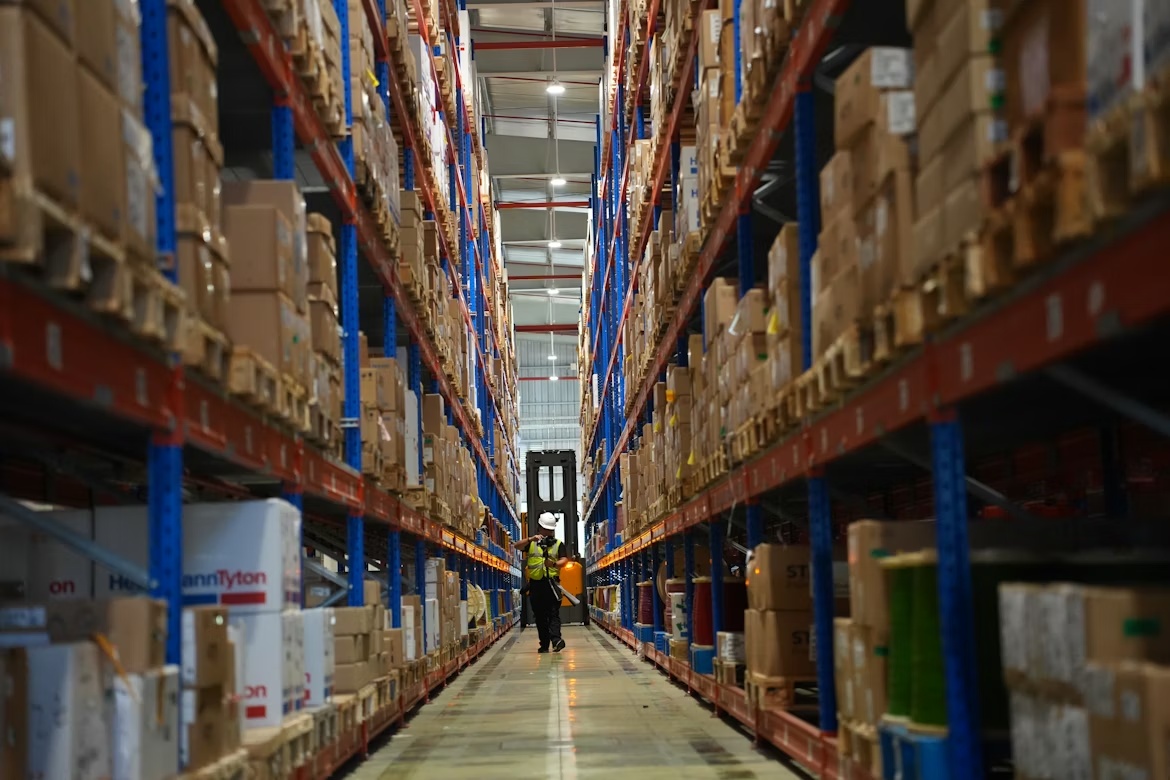 Warehouse shelves filled with product boxes representing large product catalogs and product data management in SAP environments.