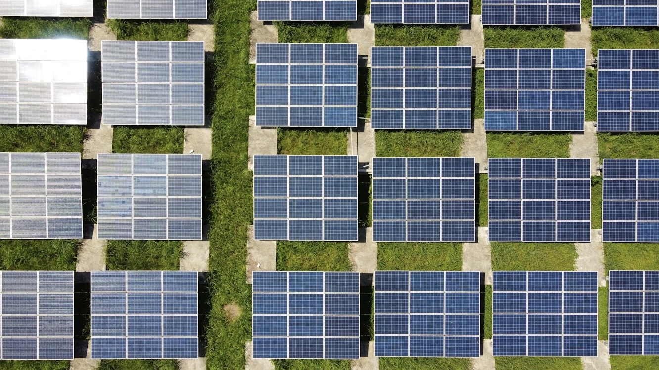Aerial view of blue solar panels in a solar energy field, representing financial and ESG data in a modern environment.