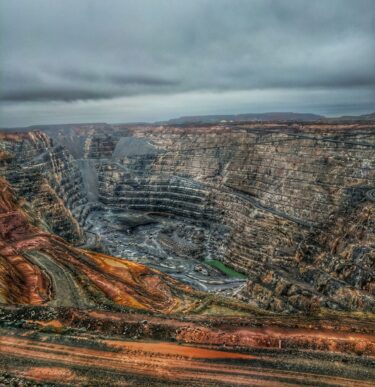 Aerial view of a large-scale open-pit mining operation showing terraced rock formations, illustrating the complex operational environment where mining ERP implementations are deployed.