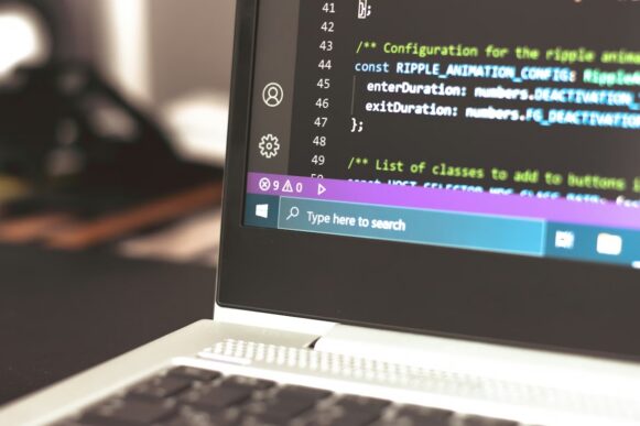 Developer working on API integration code on a laptop, representing SAP API policy changes affecting integrations and AI applications.