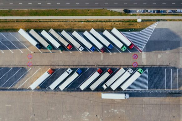 Rows of parked delivery trucks in a logistics yard representing order execution and supply chain workflows.