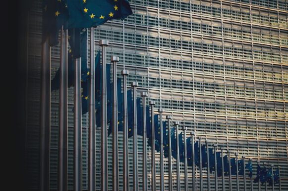 European Union flags outside the Berlaymont building in Brussels, representing EU AI Act compliance and governance rules for SAP teams.