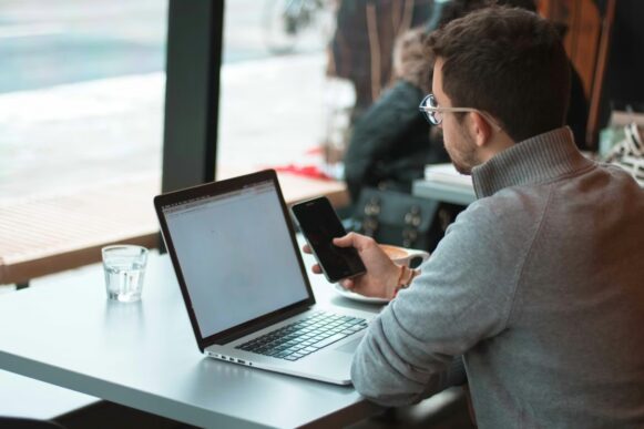 Employee checks a smartphone, representing how Rain connects SAP HCM data with earned wage access and AI-driven financial wellness.