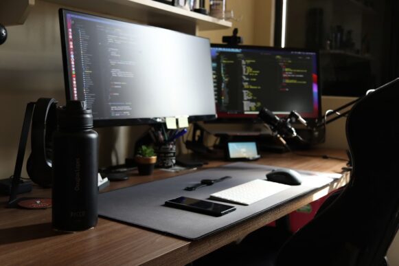 Developer workstation with dual monitors showing code, representing SAP developer tool security and software supply chain risk.