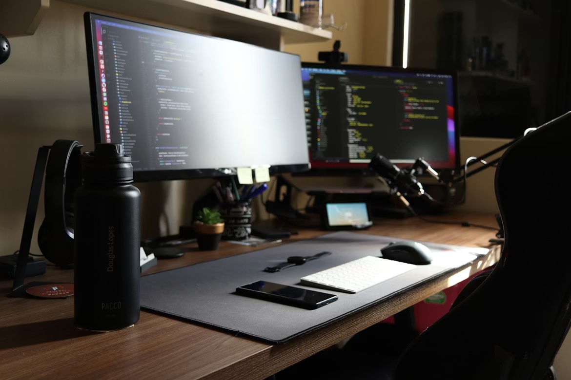 Developer workstation with dual monitors showing code, representing SAP developer tool security and software supply chain risk.