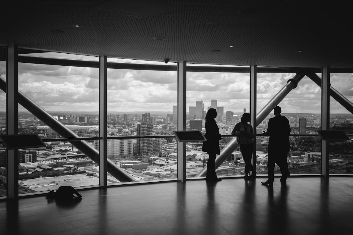 People meeting near transparent glass in an office building, representing discussions over modernizing B2B payment and SAP invoice-to-cash workflows.