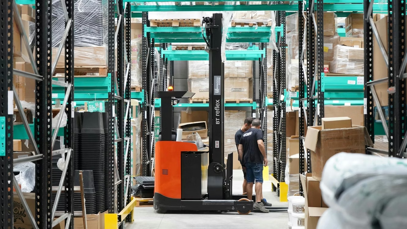 Warehouse worker operating a forklift in a distribution center, representing pricing execution across ERP and order-to-cash workflows.