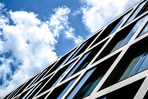 Modern glass office building against a blue sky, representing AWS IAM risk, cloud security, and SAP-connected infrastructure.