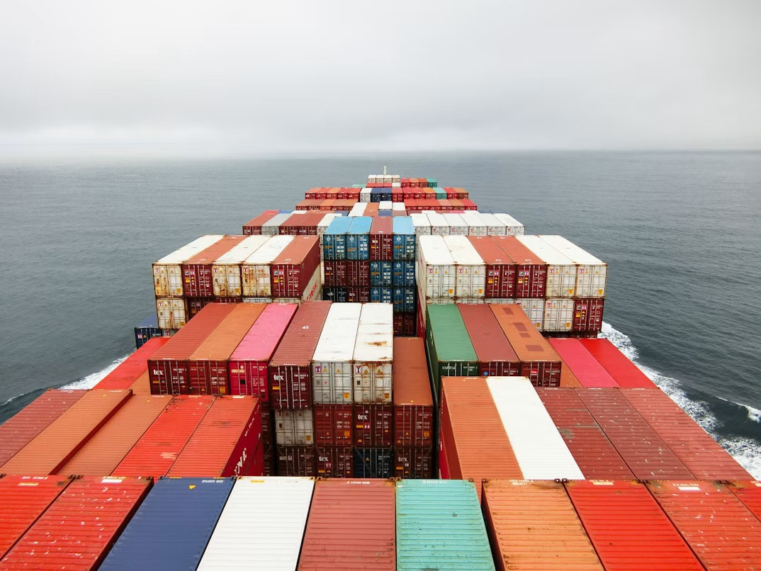 Container ship carrying imported goods affected by tariffs and manufacturing pricing pressures.