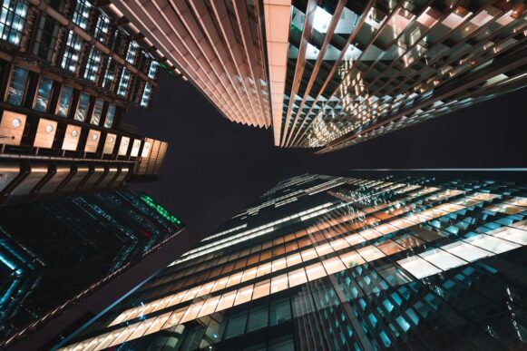 Night view of illuminated office towers, representing CFO-led ERP transformation and finance systems modernization.