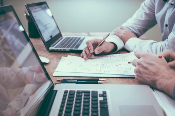 Finance professionals reviewing planning data on laptops for SAP-connected budgeting and forecasting.