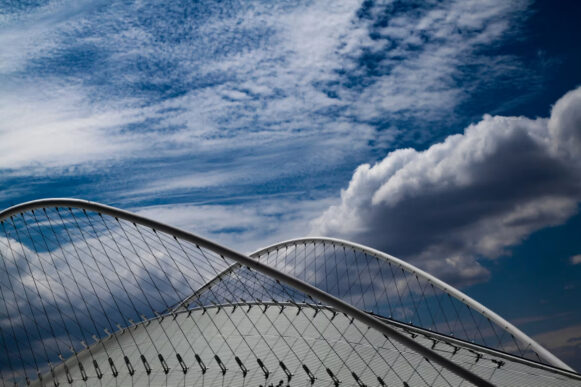 Clouds over a modern arched bridge, illustrating cloud infrastructure and SAP managed services modernization.