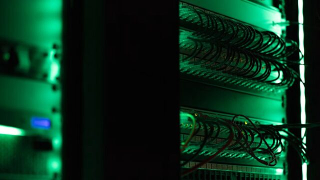 Green-lit server rack and network cables representing SAP HANA infrastructure and data archiving