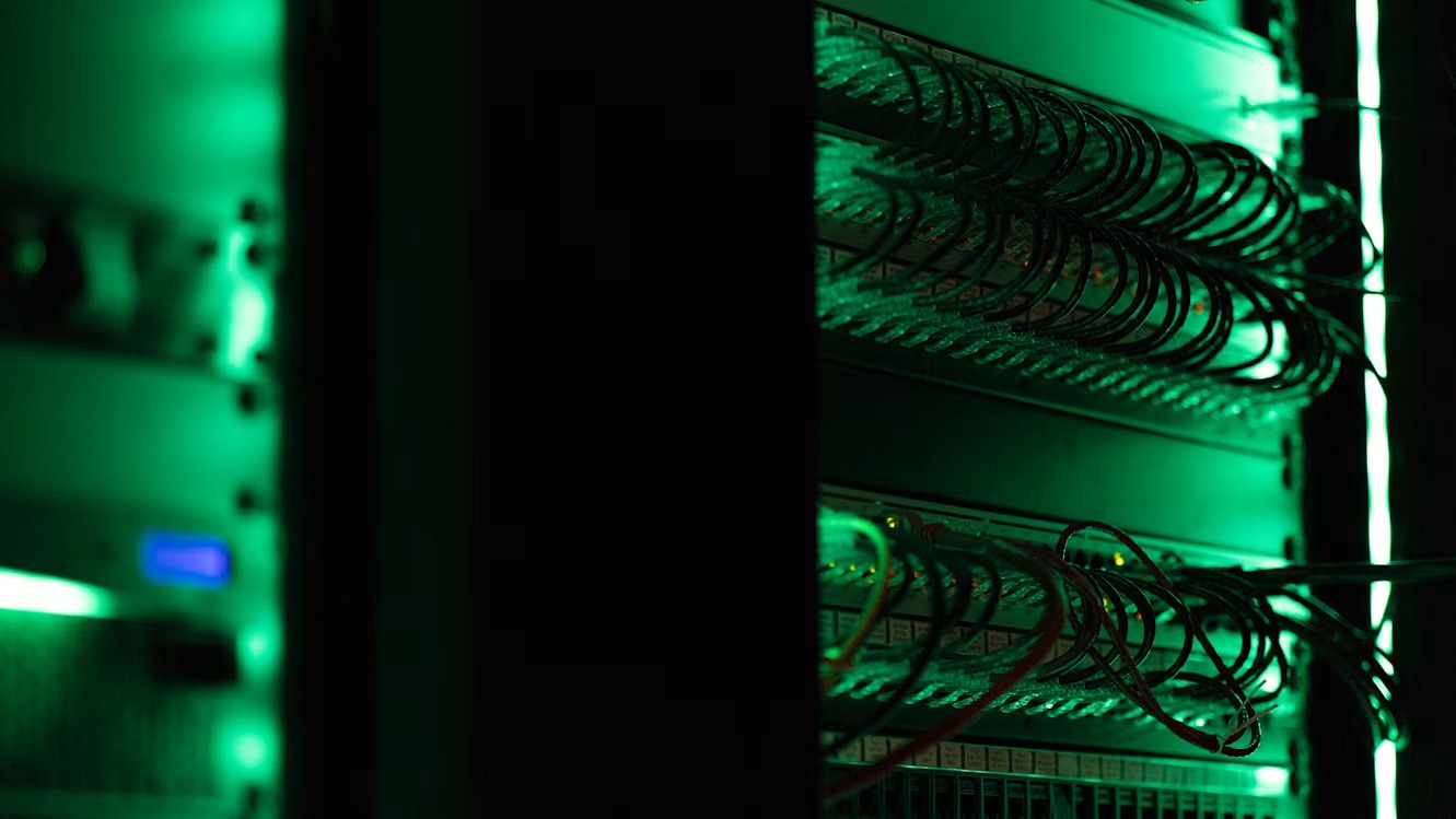 Green-lit server rack and network cables representing SAP HANA infrastructure and data archiving