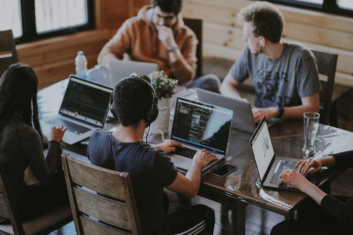 Developer team working on laptops, representing SAP n8n workflow orchestration inside Joule Studio for BTP and Business AI teams.