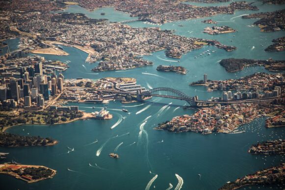 Aerial view of Sydney Harbour in Australia, where Capgemini ANZ is headquartered, showing the Sydney Opera House, Harbour Bridge, and surrounding business districts.