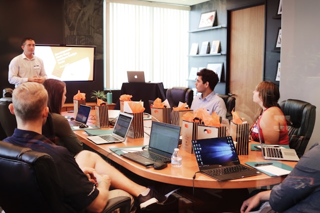 Project team gathered around a conference table with laptops during a workshop presentation, representing SAP SuccessFactors implementation planning and HR transformation collaboration