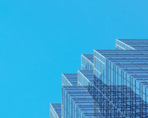 Modern glass office building representing structured agentic orchestration across enterprise workflows