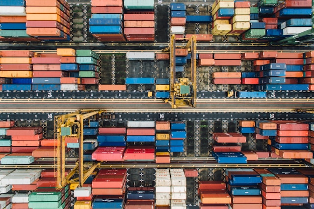 Aerial view of colorful shipping containers and yellow gantry cranes at a container port, representing retail supply chain operations modernized with SAP S/4HANA and SAP Digital Supply Chain solutions