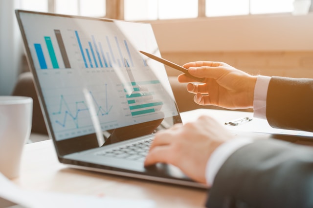 Finance professional reviewing real-time payment and transaction data on a laptop dashboard, representing how Boomi AI agents automate accounts receivable and cash application at Lexitas.
