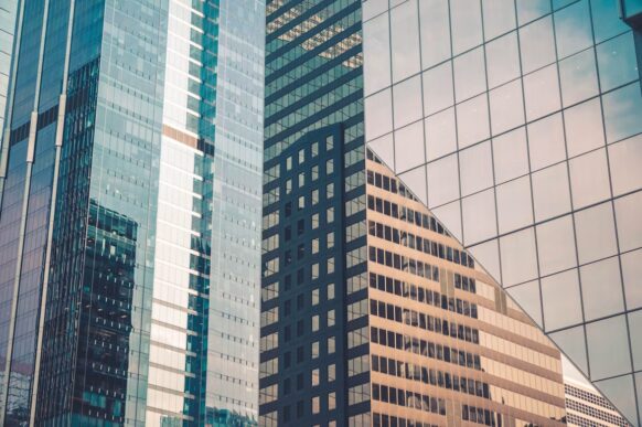 Corporate office towers representing SAP treasury, FX payments, and global finance workflows connected through Monex Open API.