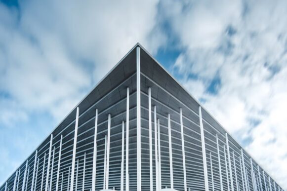 Modern building against clouds, representing managed job scheduling for RunMyJobs in RISE with SAP.