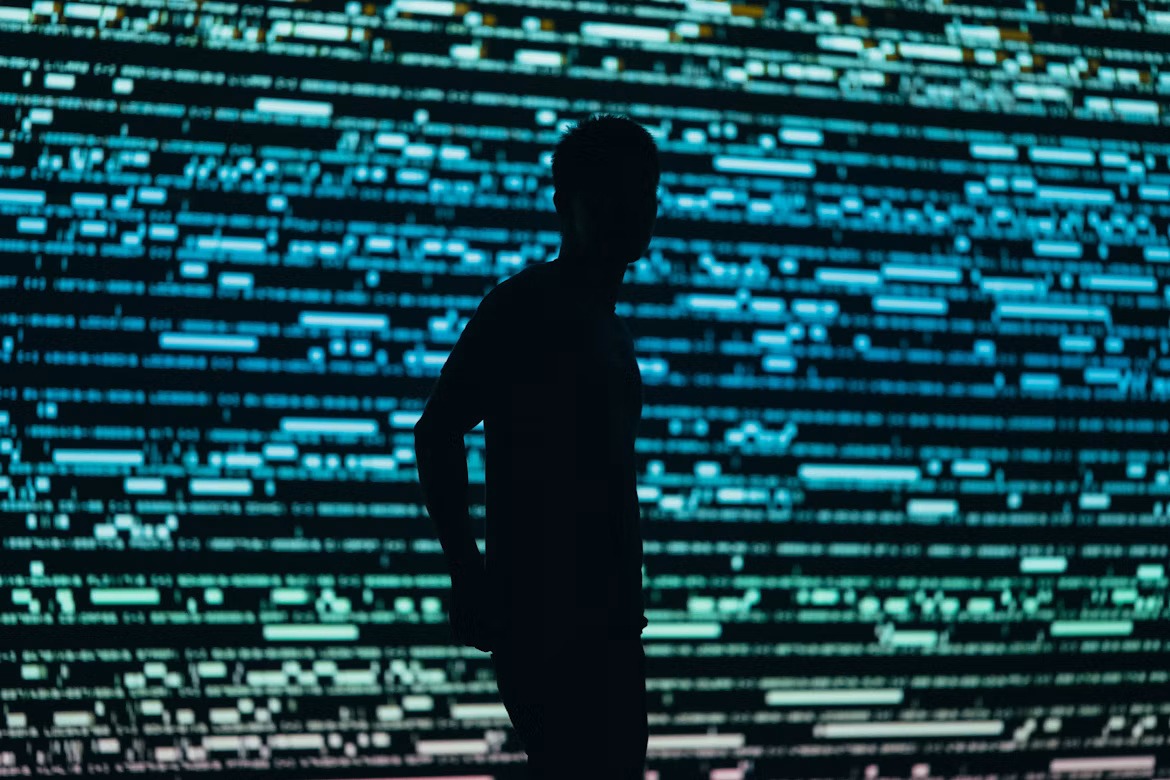 Silhouetted person standing before a digital security display representing zero trust access enforcement.