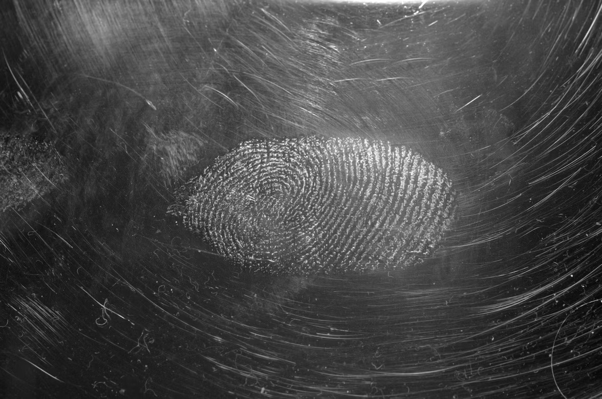Fingerprint on a reflective surface representing AI content provenance and traceability