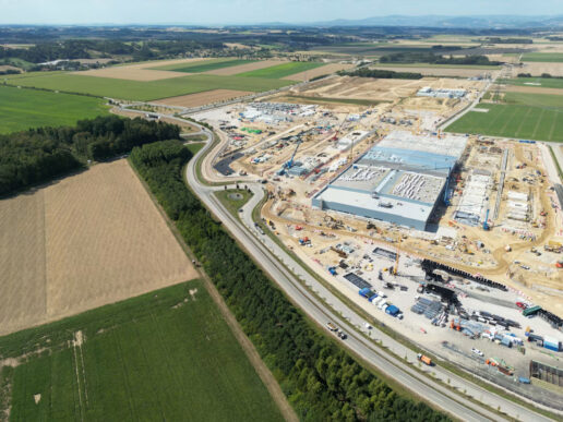 Aerial view of a large industrial construction site surrounded by farmland, illustrating data center expansion and capital project planning.
