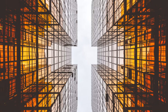 Symmetrical glass office buildings with illuminated grid patterns representing structured SAP Business One data