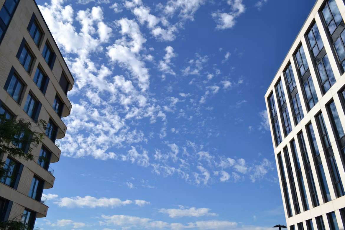 Modern office buildings beneath clouds illustrating SAP cloud sovereignty and output management.