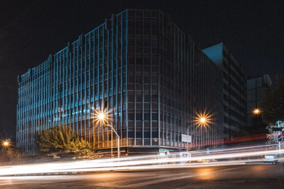 Modern office building at night with traffic light trails representing speed and control in financial close automation.