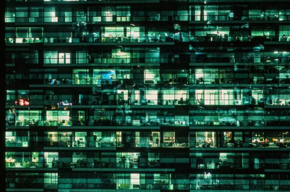 Illuminated office building windows at night, used as a metaphor for selective data access in SAP Datasphere.
