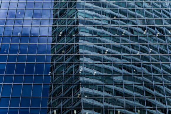 Reflections across a glass office building illustrate the enterprise systems and data foundations needed to scale AI.
