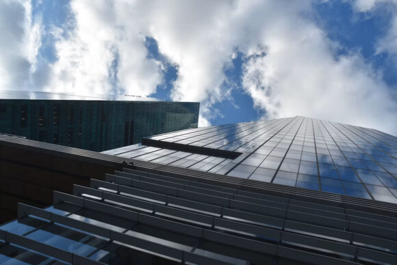 Modern office buildings beneath cloud-filled skies, illustrating hybrid cloud orchestration and enterprise infrastructure